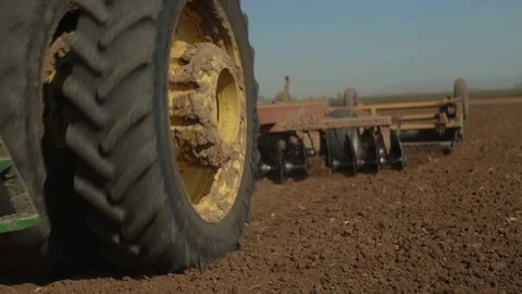 Low angle of Tractor Discing, preparing Soil Stock Footage 94643183