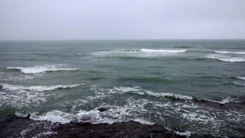 Low-Angle Turquoise Surf Smashing Into Seaside Cliffs Stock Footage 322055745
