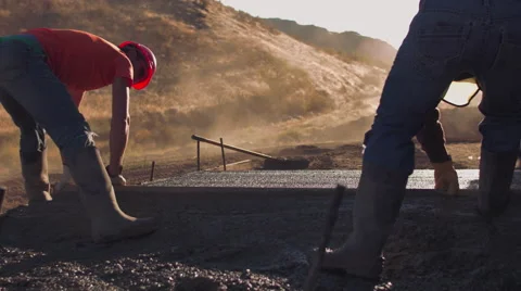 Low angle of two construction workers smoothing concrete Stock Footage 55154734