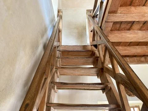 A low-angle, upward view of an old wooden staircase. Stock-Fotos