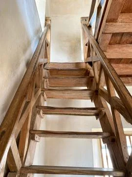 A low-angle, upward view of an old wooden staircase. 스톡 사진