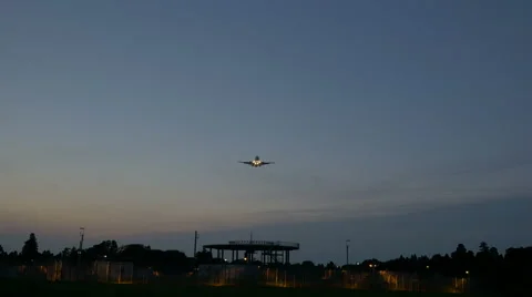 Low angle variation of an airplane descending to touchdown at twilight. Stock Footage 61807657