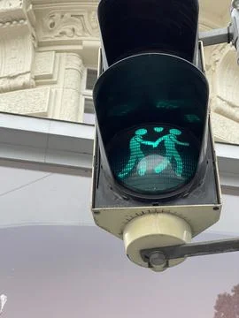 Low angle vertical close up of same sex couple traffic lights glowing green Stock Photos