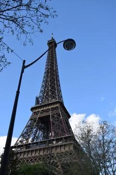 Low-angle vertical shot of Eiffel Tower in Paris, France against a blue sky Stock Photos