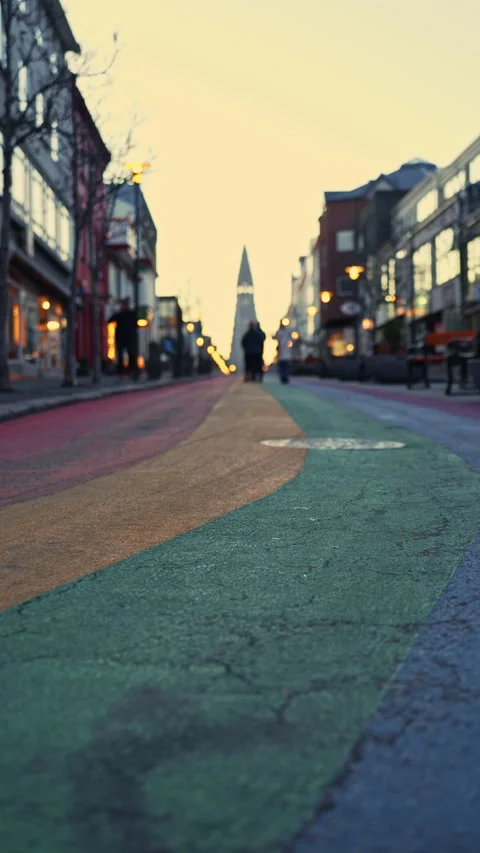 Low angle vertical shot of rainbow street at sunrise with silhouettes of pe.. Stock Footage 329865049