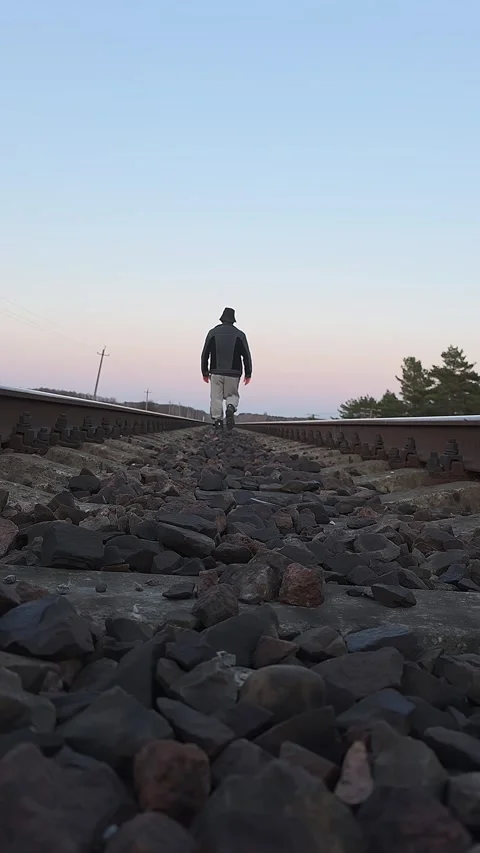 Low angle vertical video of caucasian man in jacket and hat walking away al.. Vídeos de archivo 333790962