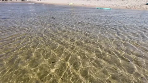 Low Angle Video of Clear Beach Water with Tourists Background The Concept o.. Stock Footage 323474560