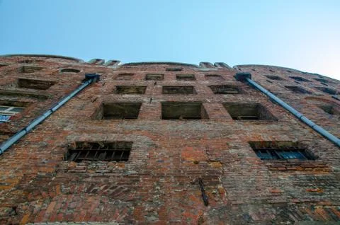 Low Angle View Of Abandoned Brick House With Broken Windows with two drainage Stock Photos