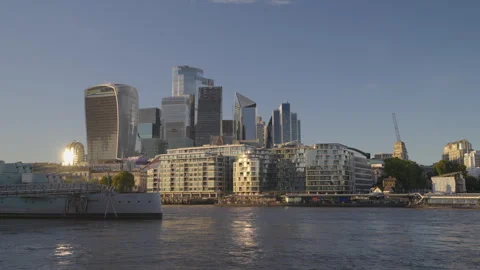 Low-angle view across the River Thames toward the City of London Stock Footage 346141906
