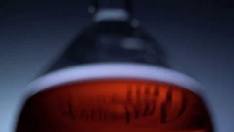 Low angle view of adding drop of black liquid in a test tube filled with red Stock Footage 75942005