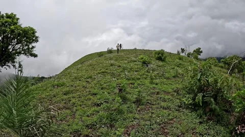 A low angle view of adventurous hikers trekking on foggy mountains wrapped .. Video stock 332353400