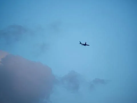 Low Angle View Of Airplane Against The Sky and orange cloud in dusk. Stock Photos