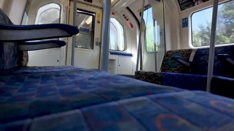 Low angle view along empty blue seats inside a moving Jubilee Line Tube Stock Footage 337873580