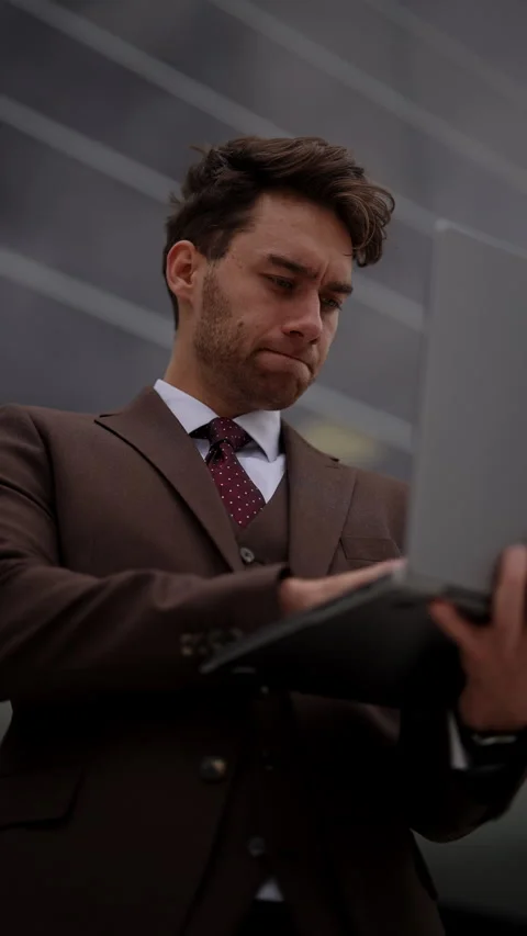 Low-angle view of ambitious young businessman in sharp suit seen working on Stock Footage 290477678