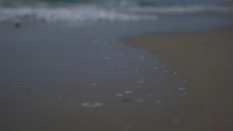 Low angle view and slow motion shot of sea shore with waves and sea foam. Stock Footage 100172255