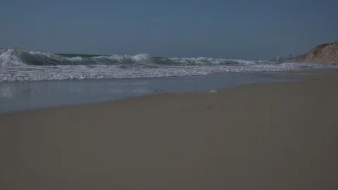Low angle view and slow motion shot of sea shore with waves and sea foam. Video stock 100172335