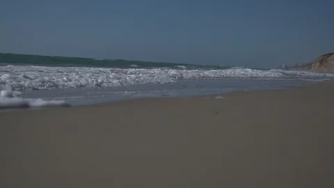 Low angle view and slow motion shot of sea shore with waves and sea foam. Stock Footage 100172729