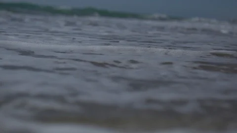 Low angle view and slow motion shot of sea shore with waves and sea foam. Stock Footage 100172744