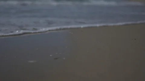 Low angle view and slow motion shot of sea shore with waves and sea foam. Video stock 100173838