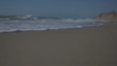 Low angle view and slow motion shot of sea shore with waves and sea foam. Video stock 100173974