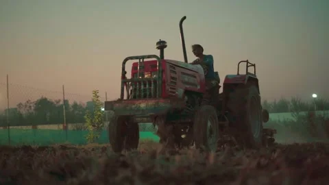 Low angle view of approaching tractor working in farm field ploughing Vídeos de archivo 332920997