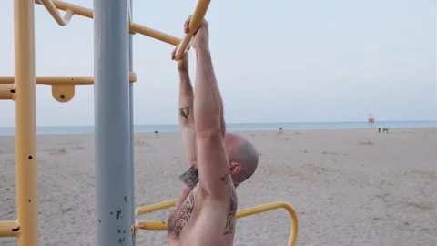 Low angle view of an athlete man doing calisthenics exercises at the beach Stock Footage 159639549