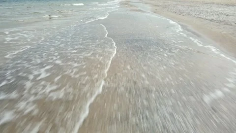 Low angle view of beach shore and the waves hitting the sand Stock Footage 245432410