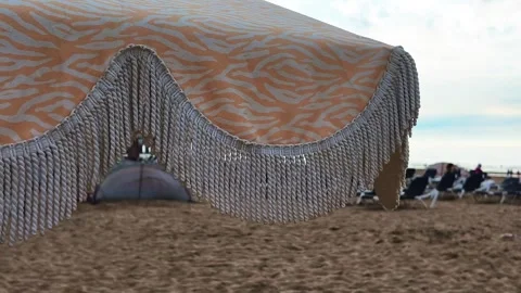 Low-angle view of a beach umbrella shielding tourists from the hot sun. Stock Footage 337349722