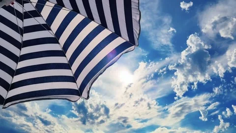 Low-angle view of a beach umbrella shielding tourists from the hot sun. Stock Footage 337349761