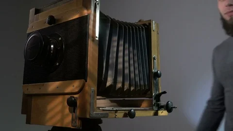 Low angle view of bearded photographer adjusting old vintage wooden photo camera Vídeos de archivo 75922677