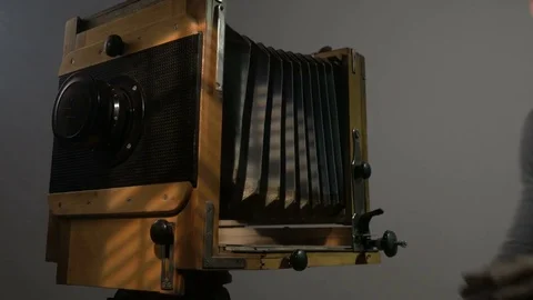 Low angle view of bearded photographer adjusting old vintage wooden photo camera Stock Footage 75924831