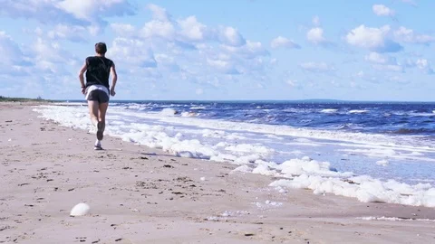 Low angle view of beautiful seethe sea shore. Running man moving to the horizon Stock Footage 82413250