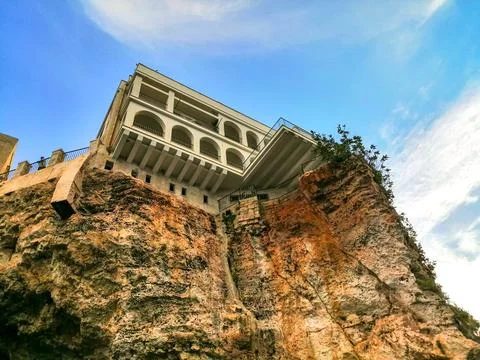 Low angle view from below of building on cliff against sky Stock Photos