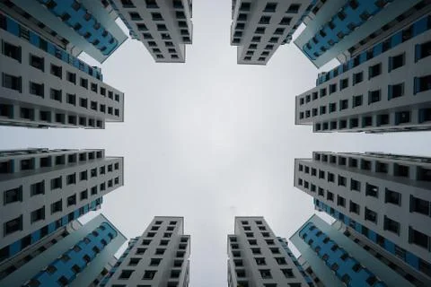 Low angle view of blue and white modern buildings under a cloudy sky Stock Photos