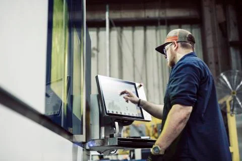 Low angle view of blue collar worker using desktop computer while working in Stock Photos