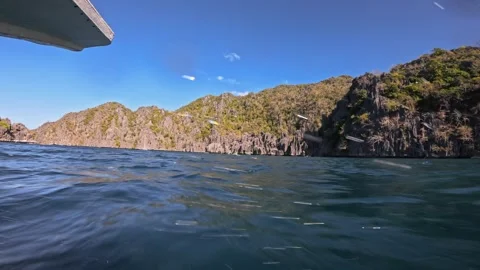 Low angle view of boat sailing on islands at sunset with water drops splashing Stock Footage 281190805