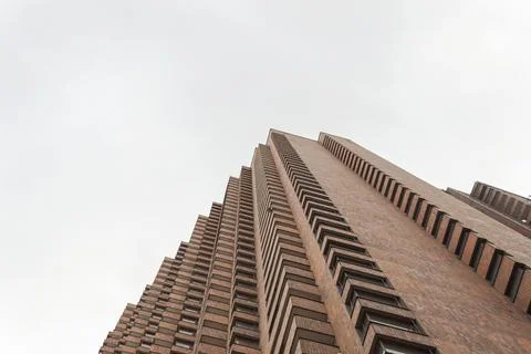 Low Angle view of a brick corner geometrical building with blue cloudy sky 스톡 사진