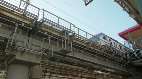 Low angle view of bridge with railways for trains. Train goes from station to Stock Footage 135737509