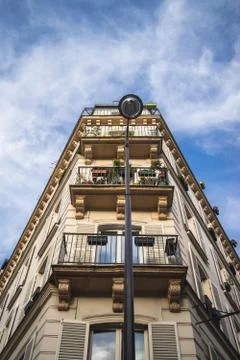 A low angle view of a building with balconies under sunlight and a blue sky i Stockfoto's