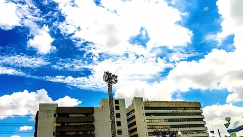 Low Angle View of Buildings Against Bright Blue Sky with Clouds 動画素材 310380065