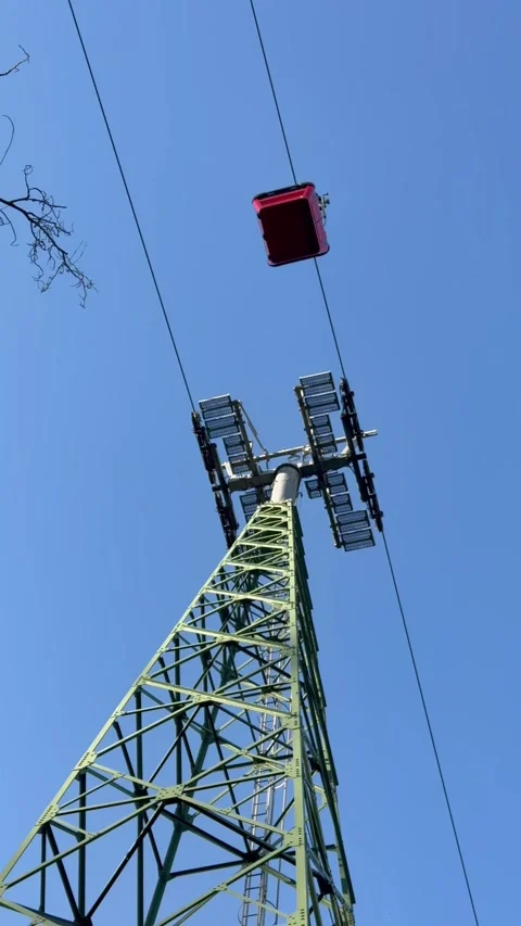 Low Angle View of Cable Car Passing Above Steel Tower Against Blue Sky - 4K Stock Footage 345455331