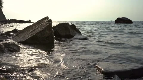 Low angle view of calm waves hitting rocky shore Stock Footage 159061675