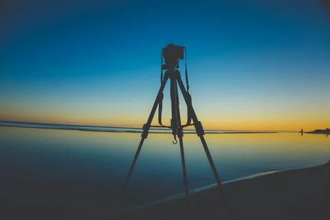 Low Angle View Of A Camera On A Tripod During Sunset 스톡 사진