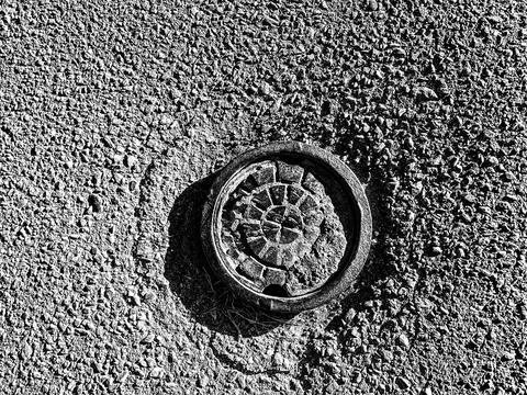 Low angle view of capped water main in residential street Stock Photos