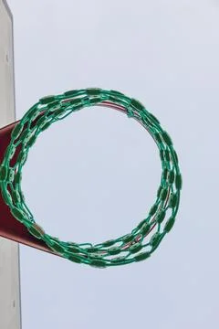 A low-angle view captures a modern basketball hoop featuring a distinctive gr Stock Photos