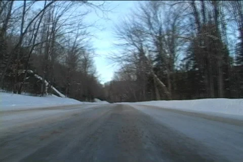 Low angle view of a car driving through remote snowy road Video stock 65640