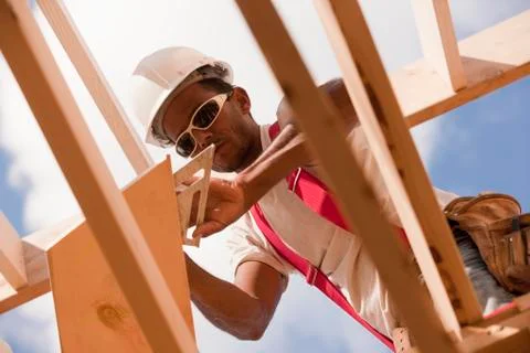 Low angle view of a carpenter marking bevel on a rafter Stock Photos