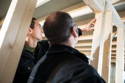 Low Angle View Of Carpenters Analyzing Wood In Incomplete Buildi 写真素材