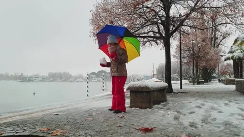 Low angle view of child playing with snow on snowy lake shore Видео 279903311