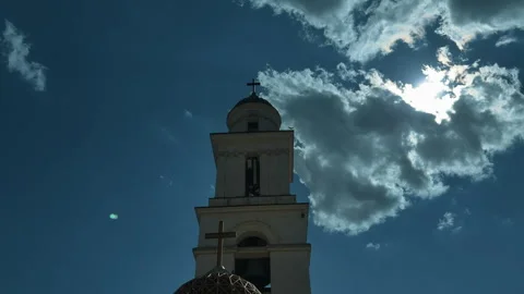 Low-angle view of church bell tower and rooftop cross over historic stone facade Vidéo 346083814